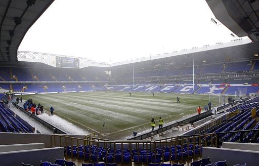 Groundstaff attempt to clear the pitch of snow at White Hart Lane in London on January 20, 2013